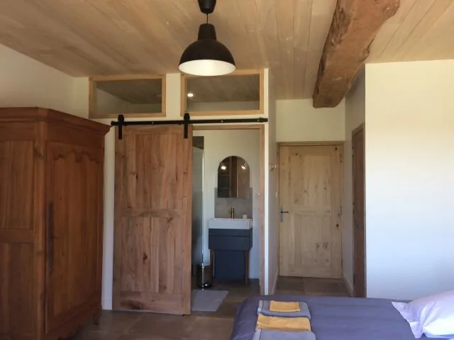 Chambre avec porte coulissante en bois et accès direct à la salle d'eau