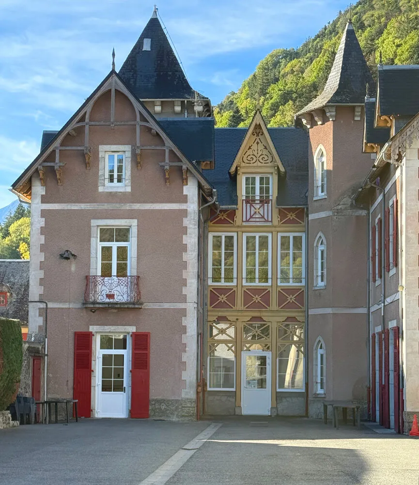 Gîte de groupe Château Rolland à Guchen — Façade du Château Rolland avec ses tourelles et sa toiture d'ardoise face à la montagne, capacité 75 personnes