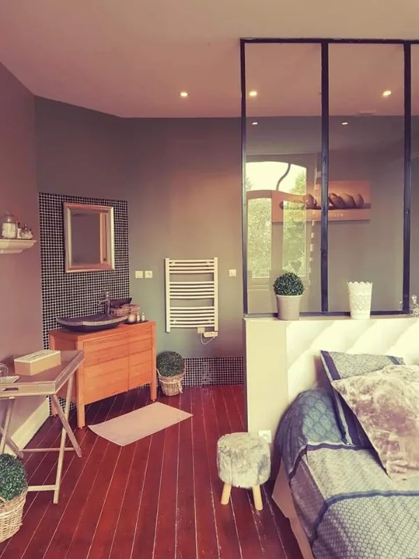 Chambre lumineuse au style loft avec verrière, lit double et salle d'eau attenante