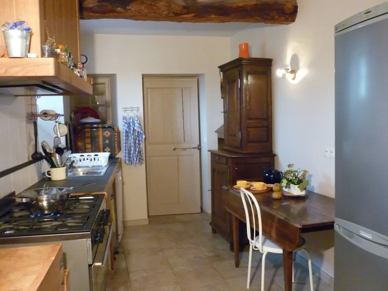Cuisine équipée avec meubles en bois et plan de travail carrelé