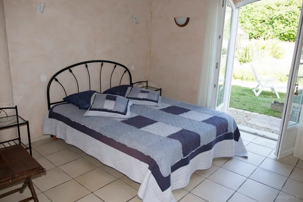 Chambre double avec tête de lit en fer forgé et accès direct au jardin
