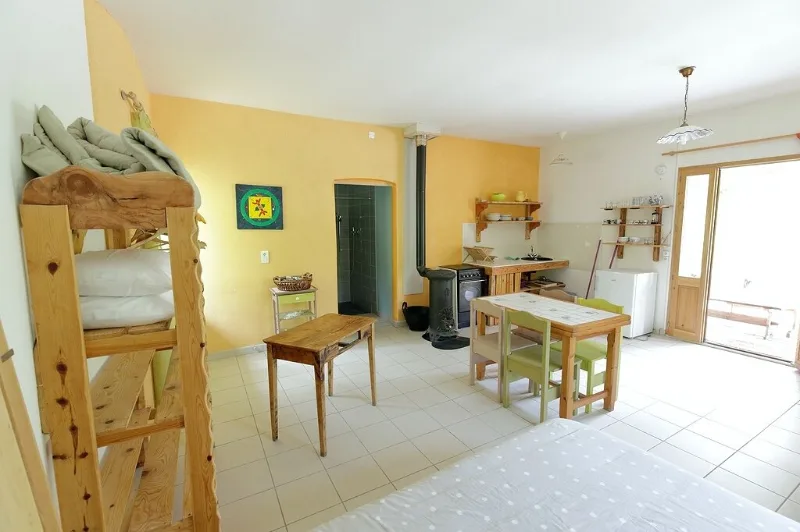Séjour et cuisine équipée du gîte du Moulin avec poêle à bois et coin repas
