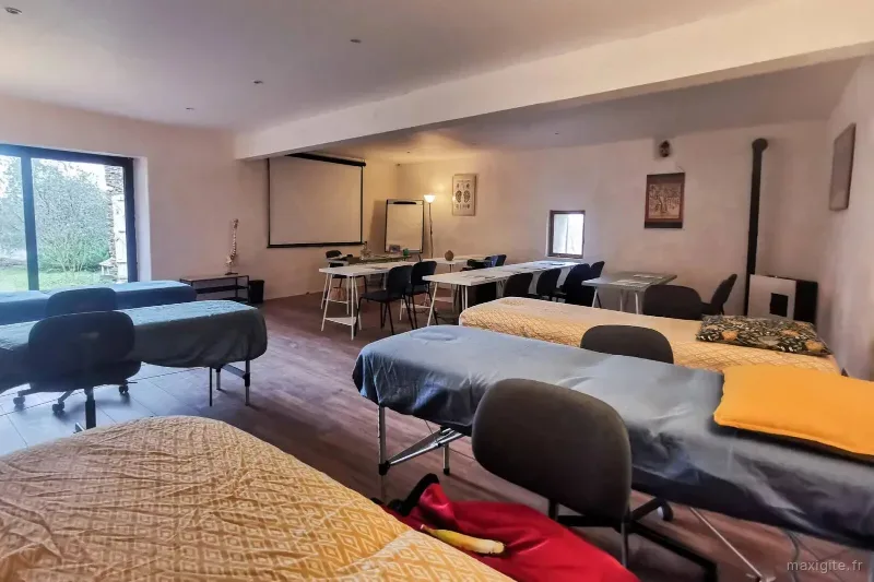 Grande salle modulable avec vue sur la nature, aménagée en espace de formation et de bien-être