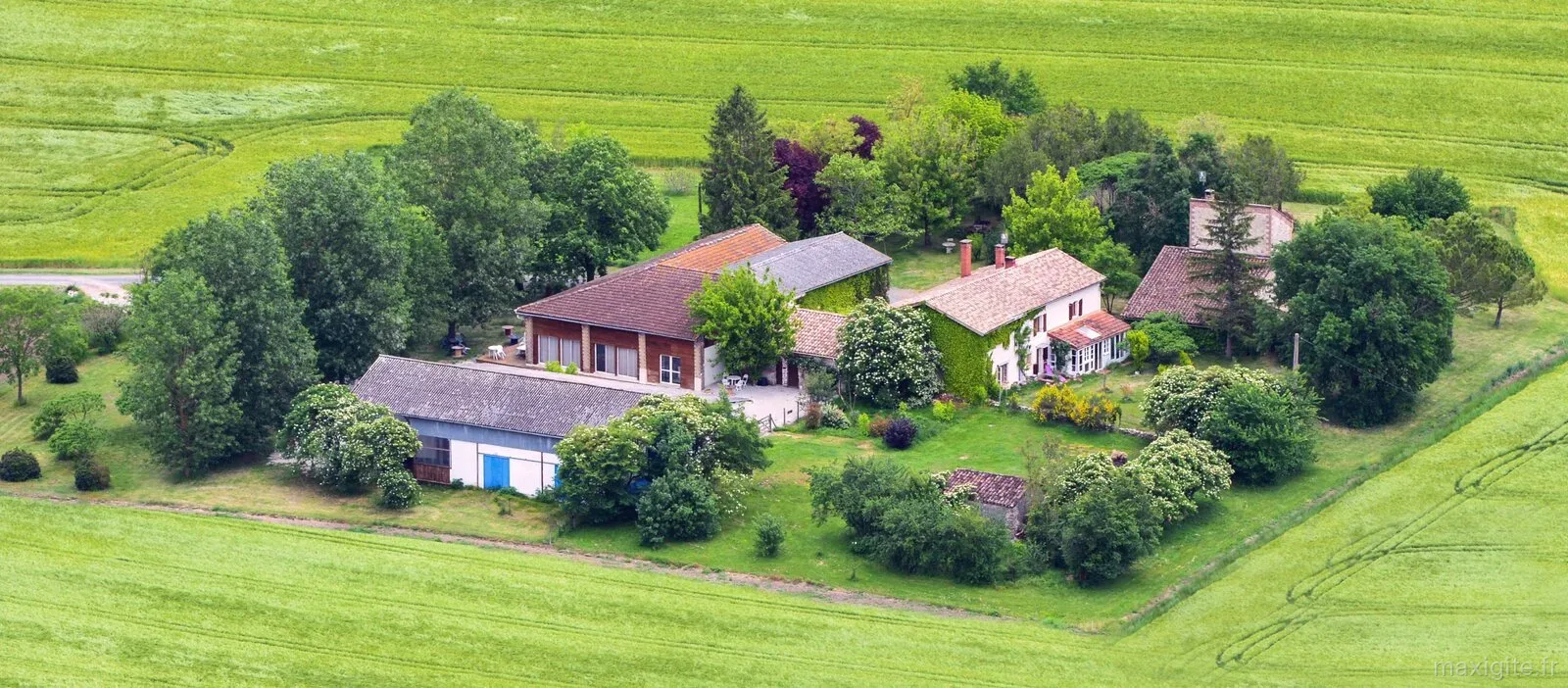 Gîte de groupe Les Hangars de Piol à Cadalen — Vue aérienne du domaine avec ses bâtiments en pierre, jardin arboré et champs alentour, capacité 20 personnes
