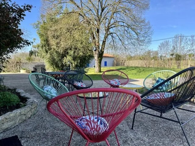 Terrasse exterieure coloree avec salon de jardin et assises conviviales