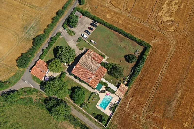 Vue aerienne du domaine avec grande batisse, piscine et terrain arbore
