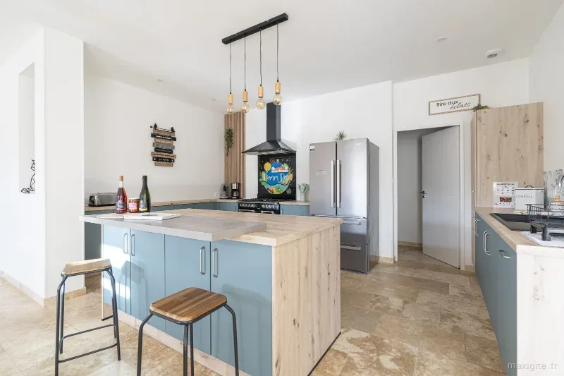 Cuisine ouverte tout equipee avec ilot central bleu et bar petit-dejeuner