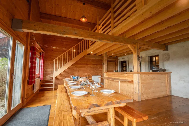 Salle a manger en bois avec mezzanine et grande table dressee