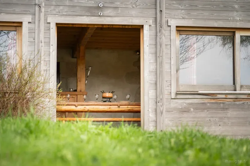 Terrasse couverte en bois avec table et vue sur le jardin verdoyant