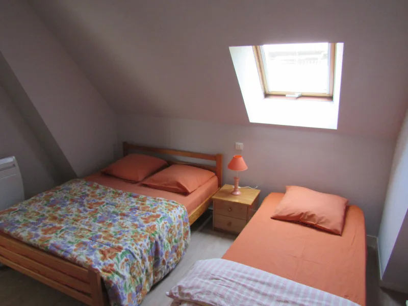 Chambre mansardee avec lit double fleuri, lit simple et velux