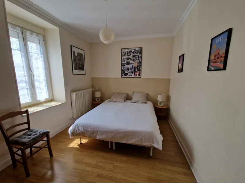 Chambre double moderne avec affiches de voyage et grande fenetre lumineuse