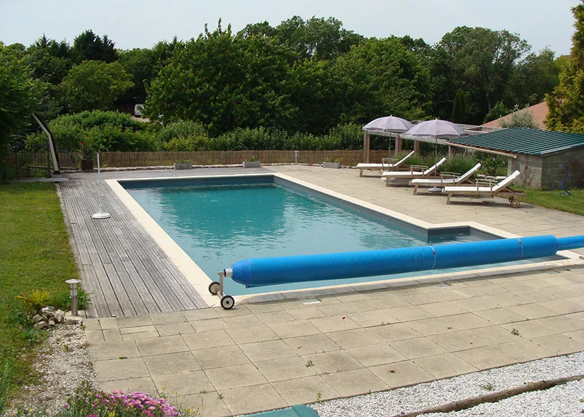 Gîte de groupe Hamac et Macarons à Échallat — Piscine exterieure entouree d'une terrasse en bois avec transats et parasols, capacité 15 personnes