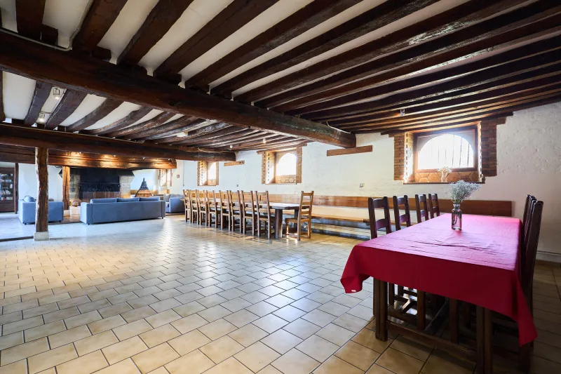 Grande salle à manger avec longue table en bois pour recevoir tout le groupe