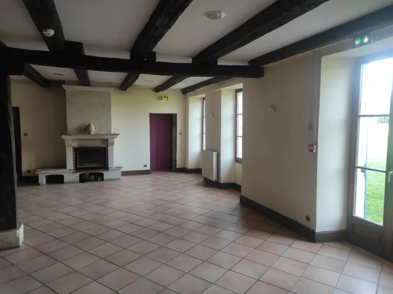 Grande salle de réception avec cheminée en pierre et accès direct au jardin