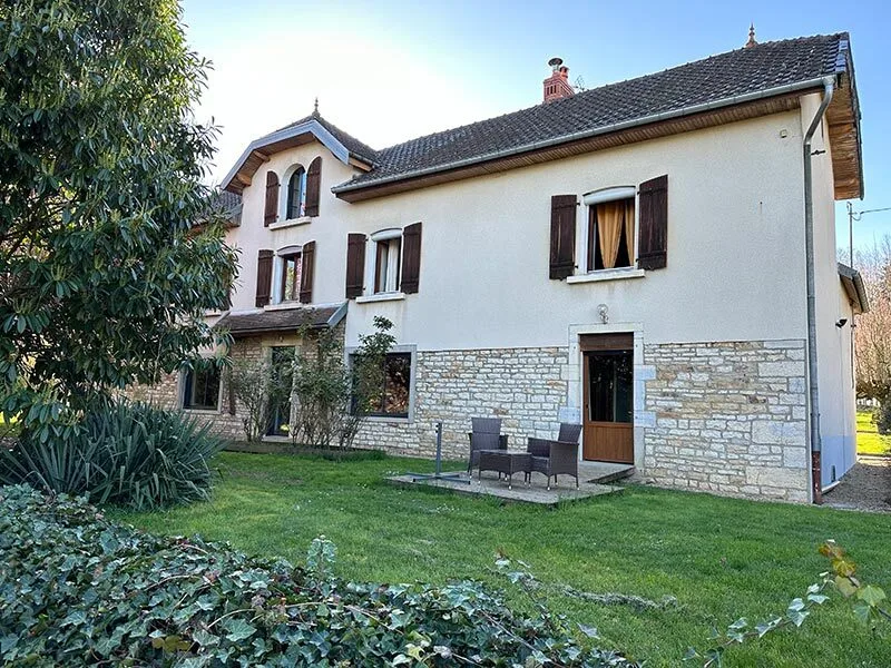 Gîte de groupe Gîte la Corne Aux Vaches à Frétigney-et-Velloreille — Façade en pierre et crépi clair du gîte entouré d'un grand jardin arboré, capacité 21 personnes