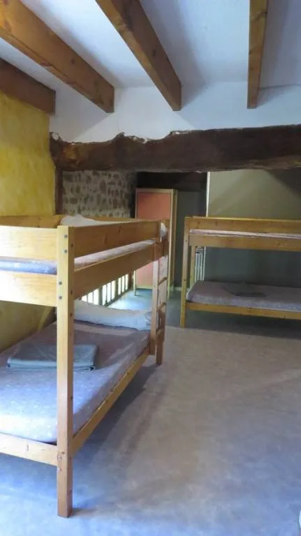 Dortoir avec lits superposés en bois sous charpente apparente
