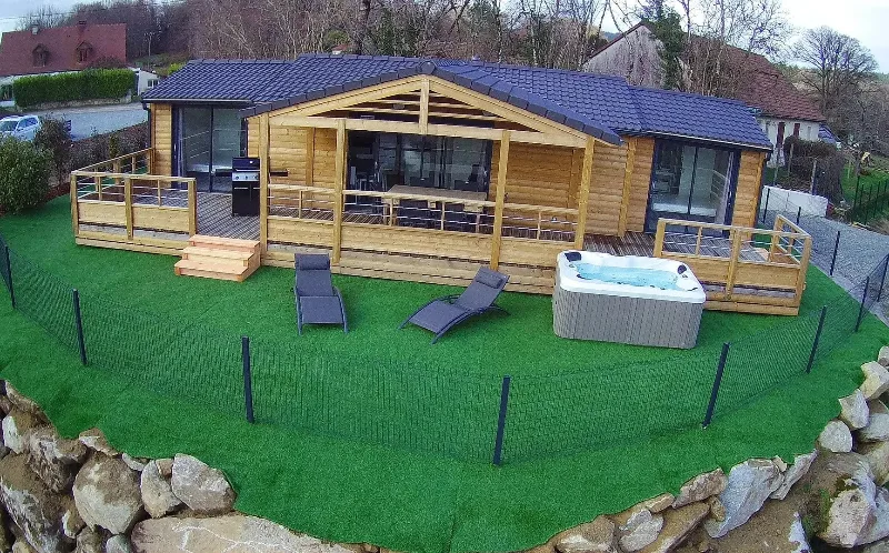 Second chalet en bois avec terrasse couverte, transats et jacuzzi extérieur