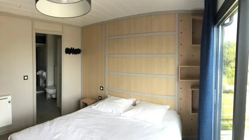 Chambre lumineuse avec grand lit double et salle d'eau attenante