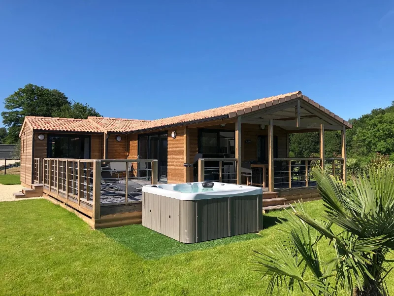 Chalet en bois avec grande terrasse, jacuzzi privé et pelouse arborée