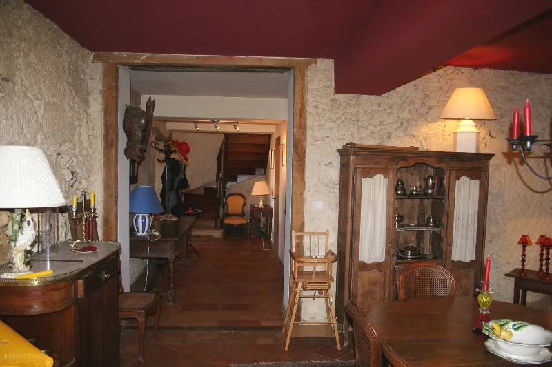 Salle à manger rustique aux murs en pierre avec meubles anciens et vaisselier