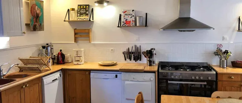 Cuisine fonctionnelle avec plaques de cuisson, hotte, deux lave-vaisselle et grand plan de travail en bois