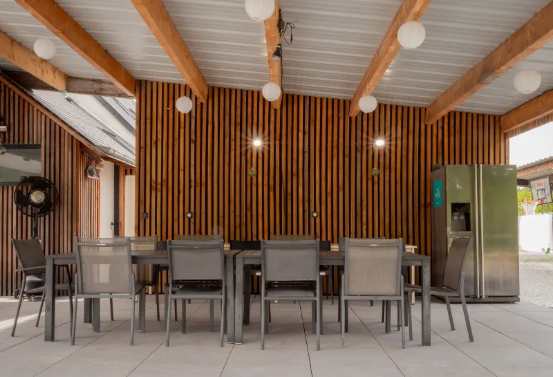 Grande véranda couverte avec longue table pour tout le groupe et guirlandes de lampions