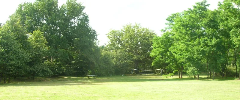 Vaste parc arboré de 8000 m² avec pelouse, filet de volley et arbres centenaires