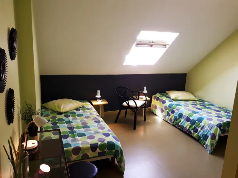 Grande salle commune avec longue table pour dix-sept convives et photos de pêche encadrées