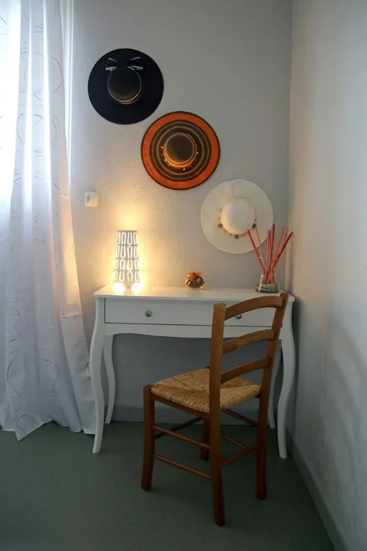 Chambre lumineuse avec deux lits simples, tons prune et velux dans les combles