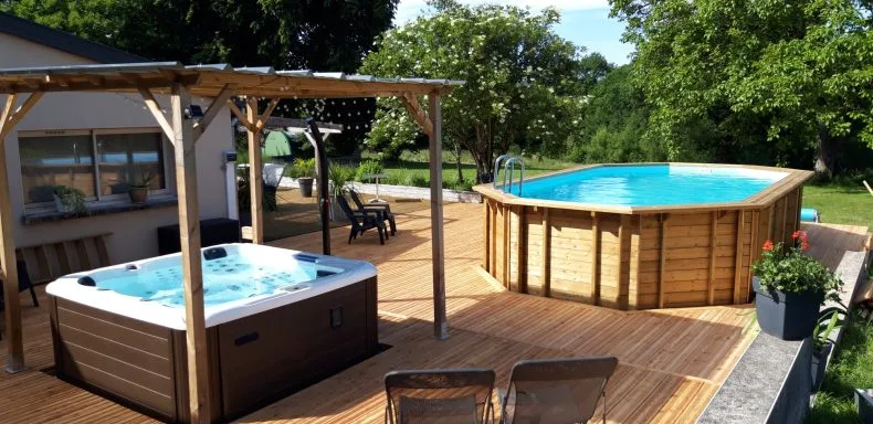 Piscine en bois surélevée avec spa privé sous pergola en bois sur terrasse ensoleillée