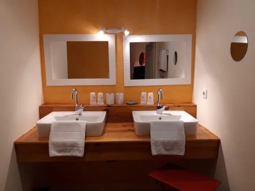 Salle de bain double vasque avec meuble en bois et miroirs éclairés