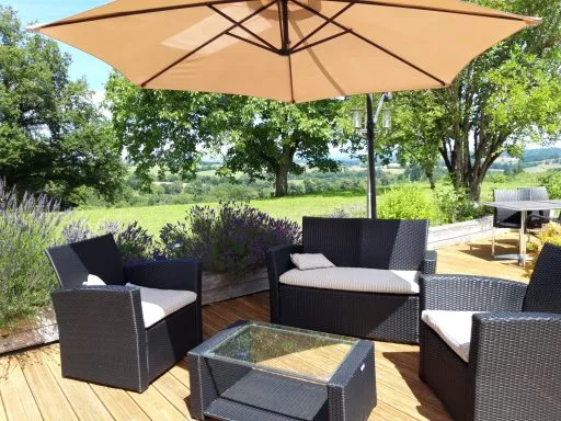 Terrasse en bois avec salon de jardin et vue dégagée sur la campagne corrézienne