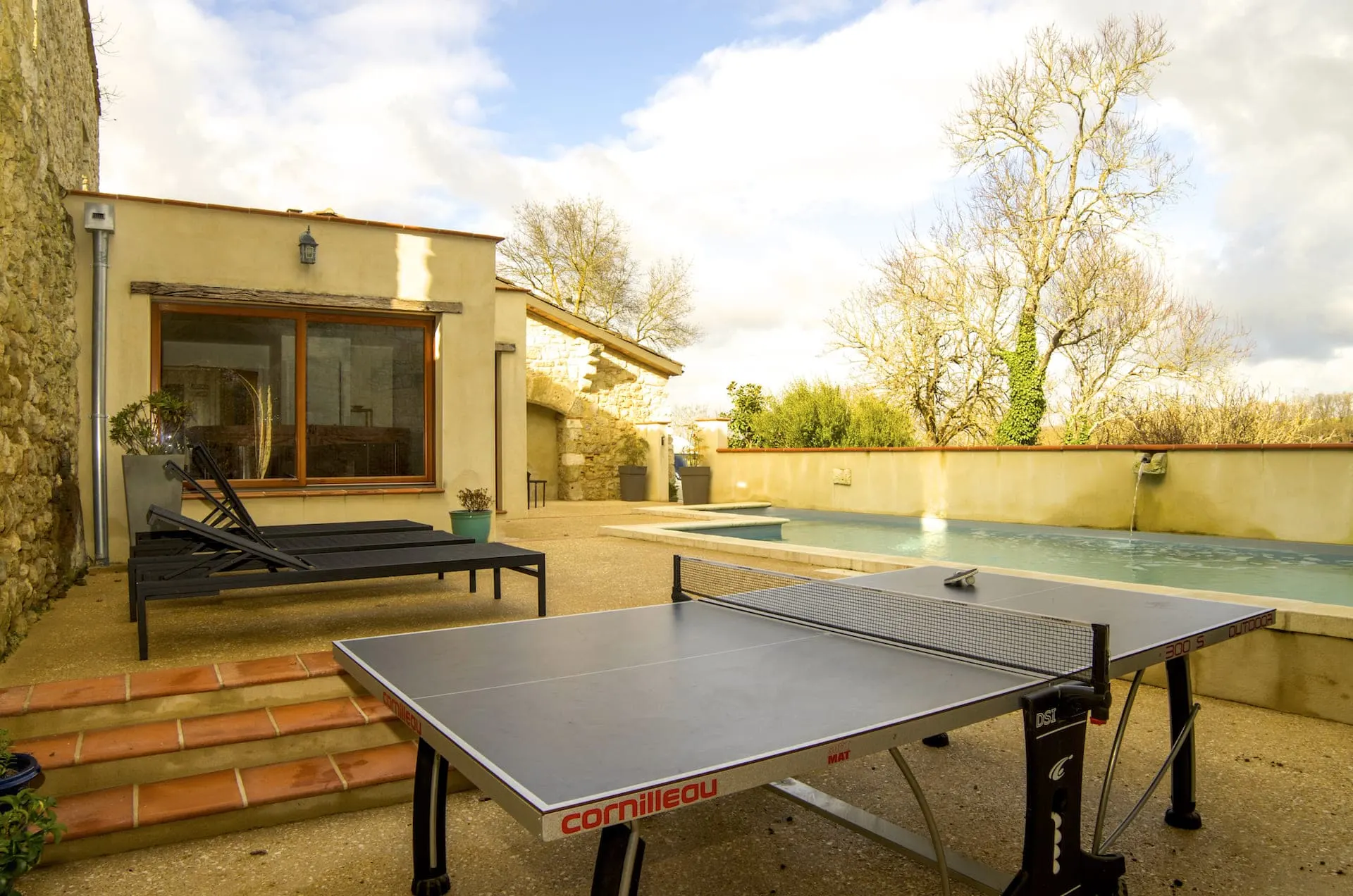 Table de ping-pong au bord de la piscine chauffée
