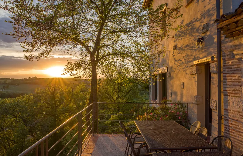 Terrasse plein sud au coucher de soleil avec salon de jardin