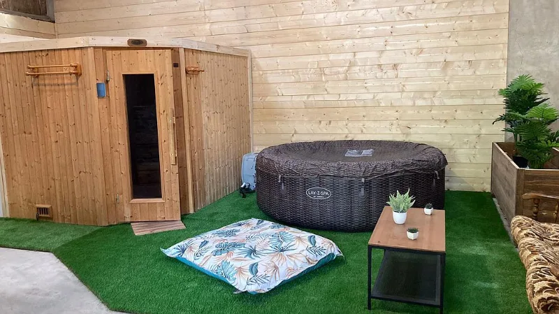 Espace détente intérieur avec sauna en bois et spa gonflable