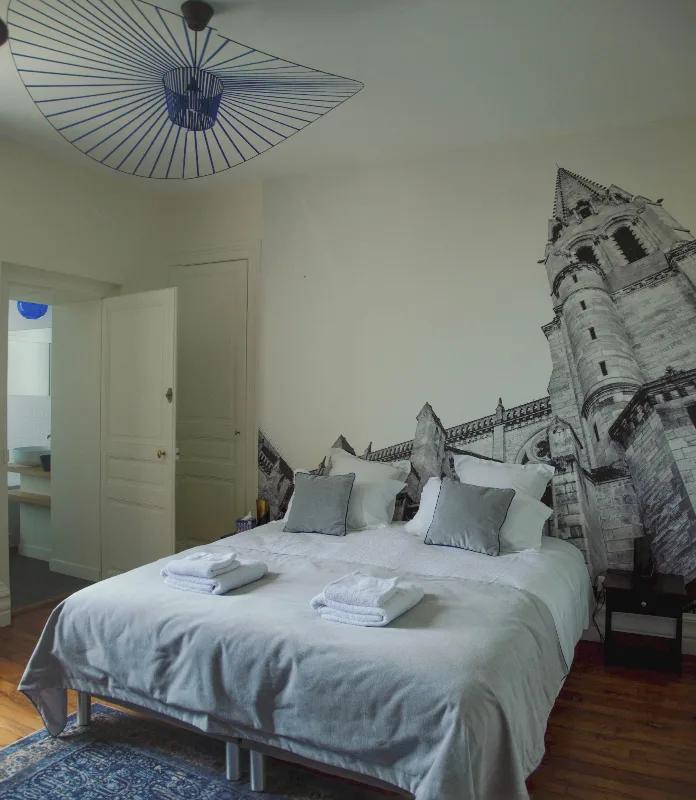 Chambre l'Architecturale avec fresque murale d'une cathédrale et lit double cosy