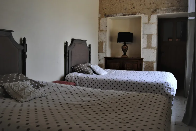 Chambre double aux tons taupe avec meuble ancien en niche de pierre