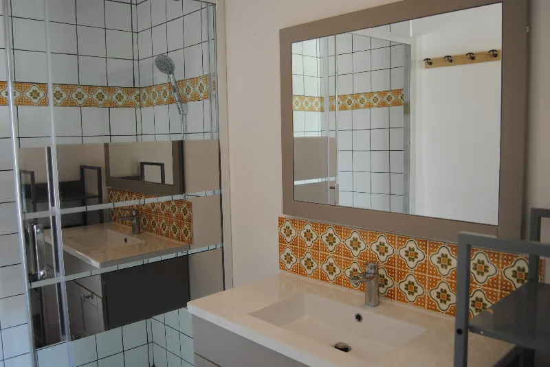 Salle de bain avec double vasque et faïence à motifs orangés
