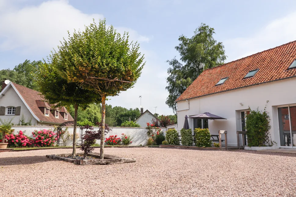 Gîte de groupe Le Domaine du Moulinel à Saint-Josse — Cour gravillonnée entre les deux bâtiments du domaine, jardin fleuri et toits en tuiles, capacité 28 personnes