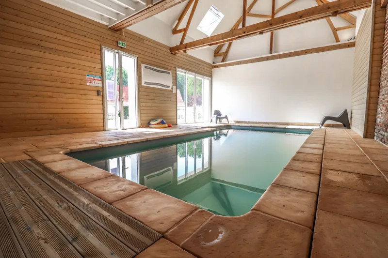Piscine intérieure chauffée sous charpente en bois, accessible toute l'année