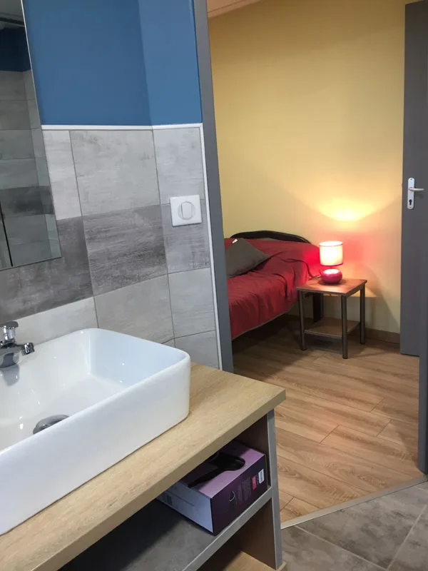Chambre avec salle de bain privative attenante et lavabo vasque