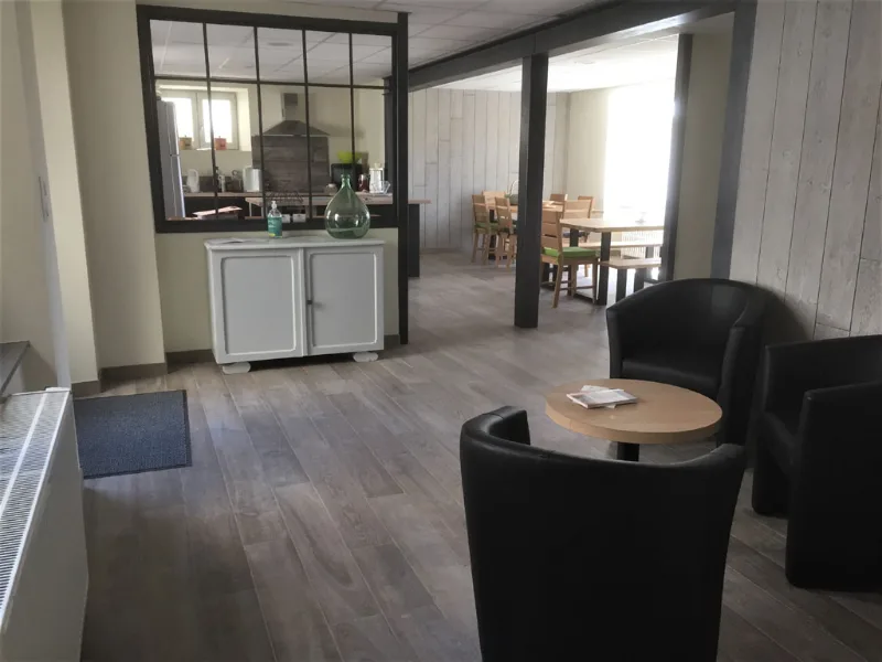 Salon-cuisine ouvert avec grande table en bois et coin repas lumineux