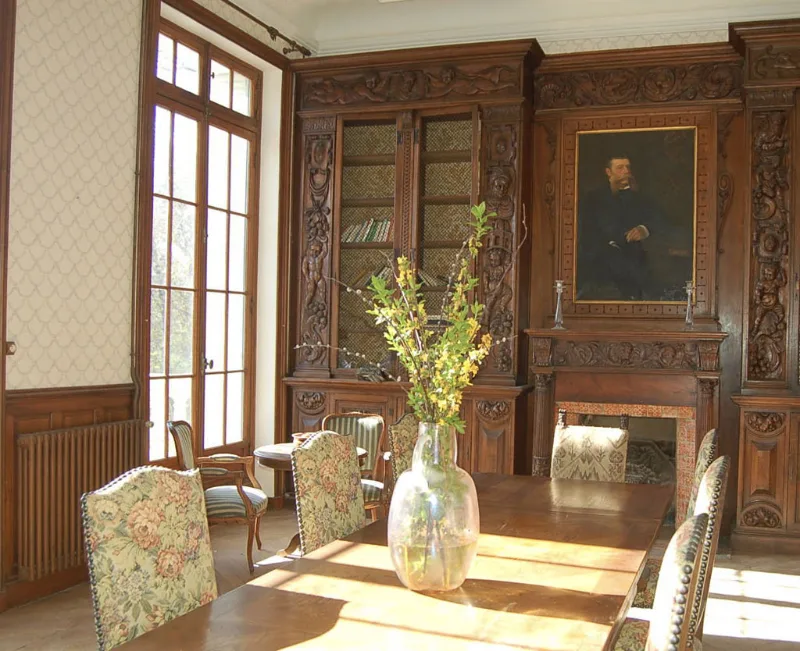 Salle a manger boisee avec cheminee sculptee et portrait ancien