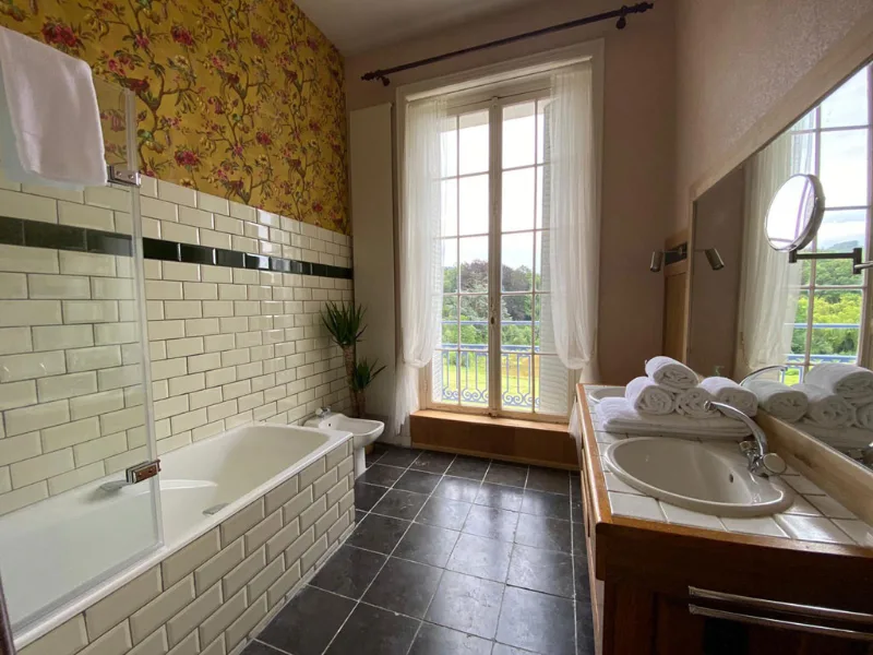Chambre avec parquet en chevrons, lit double et grandes fenetres sur le parc