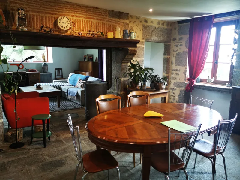 Sejour interieur avec cheminee, fauteuil rouge et grande table ronde