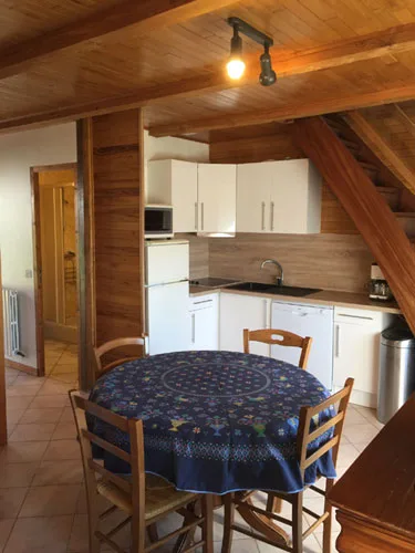 Cuisine cottage en bois avec coin repas et table ronde