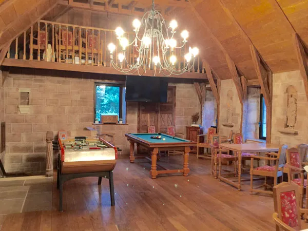 Salle de jeux avec mezzanine, billard et baby-foot sous charpente apparente