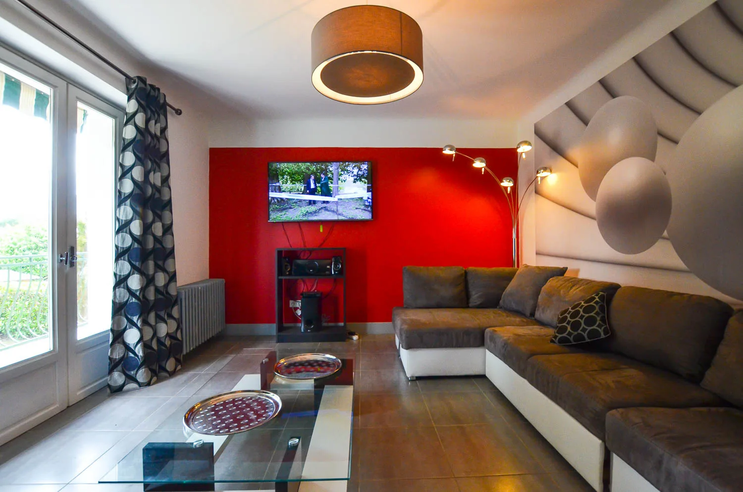 Salon aux murs rouges avec canapés et cheminée pour veillées conviviales