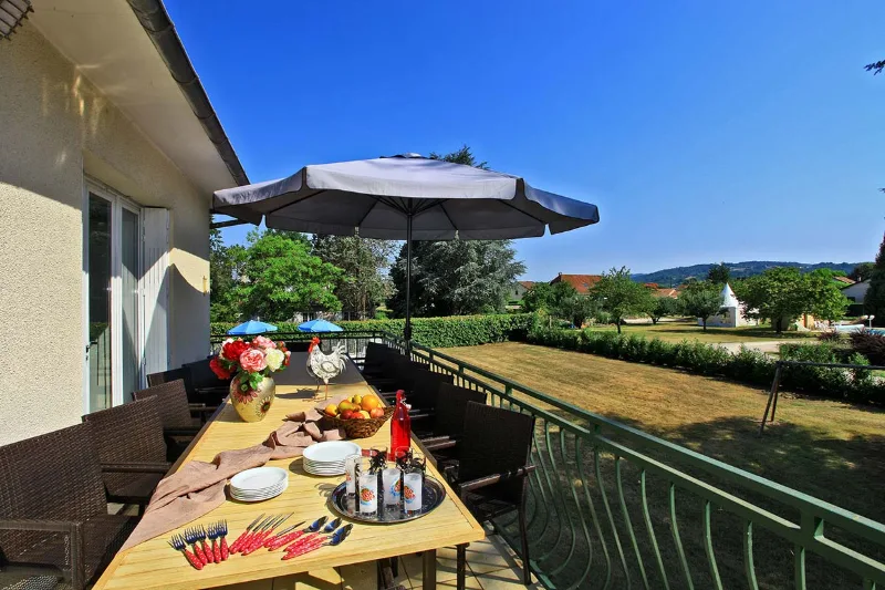 Terrasse extérieure avec grande table dressée pour un repas de groupe