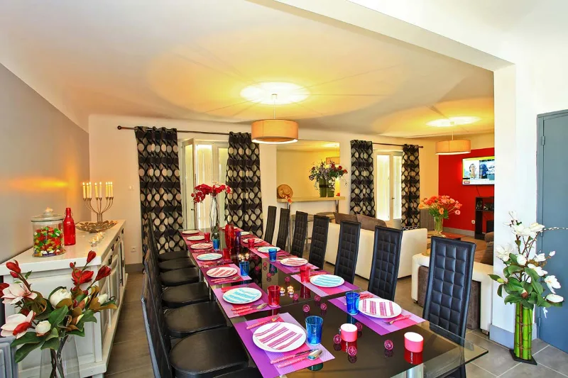 Salle à manger avec longue table en bois pouvant accueillir seize convives